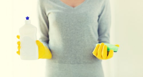 Professional cleaner preparing a tidy E5 home interior for a domestic cleaning visit